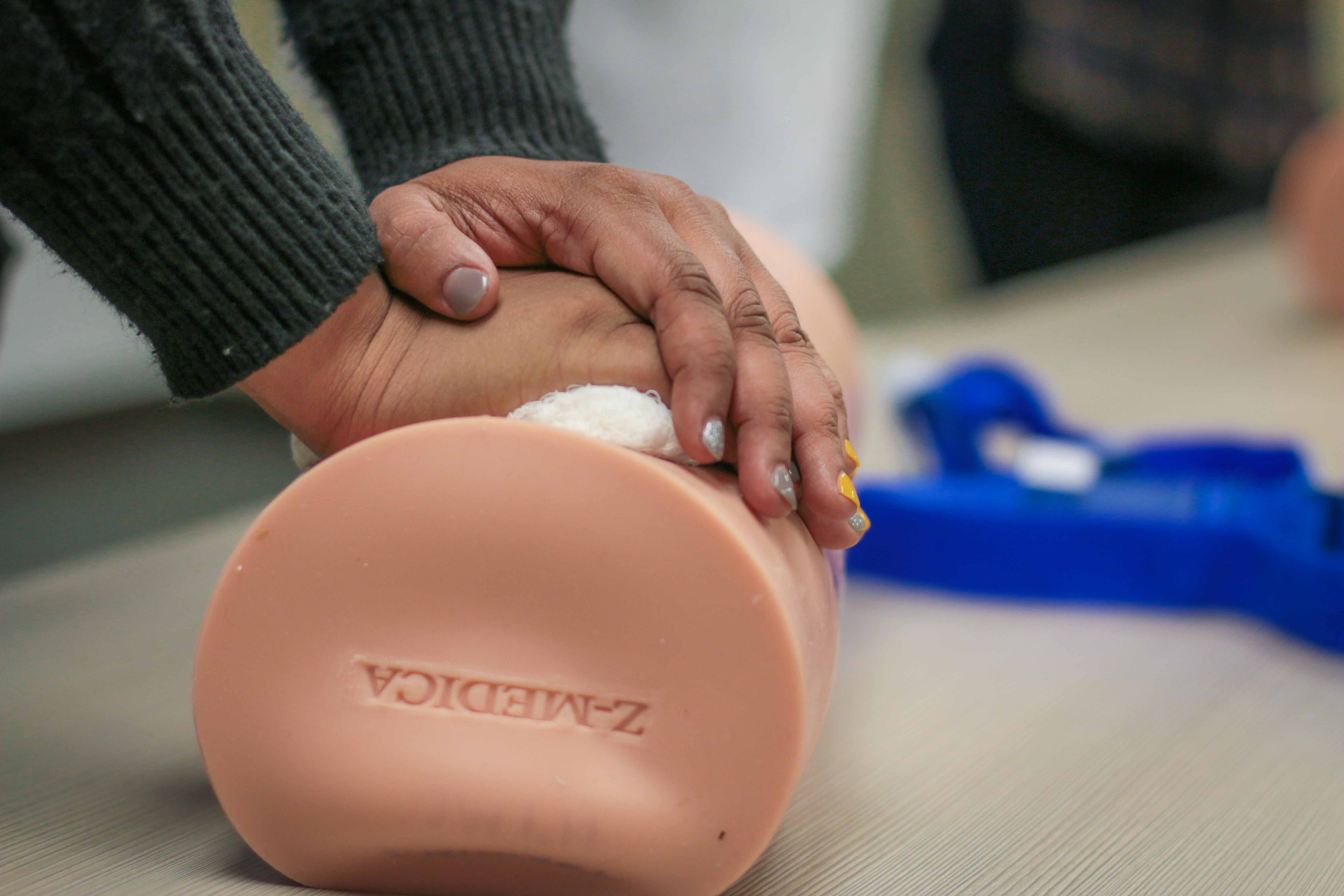 A woman practices life-saving techniques during a Stop the Bleed class