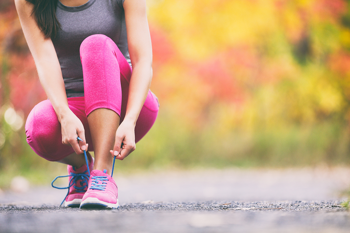 Runner tying running shoes laces on an outdoor track