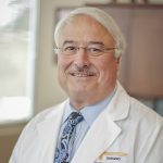 John Bell MD of The University of Tennessee Medical Center's Cancer Institute sits in his office wearing a white lab coat