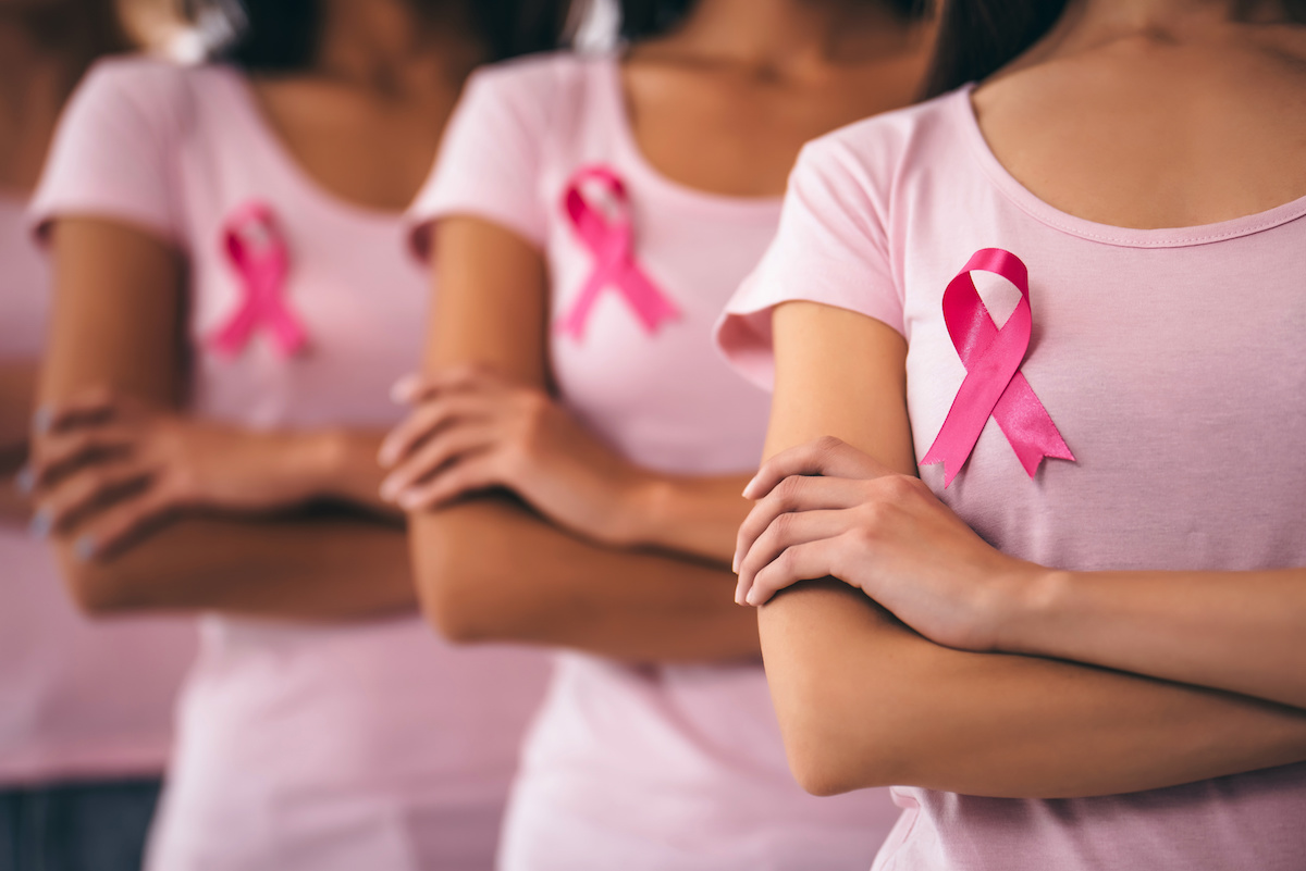 Cropped image of group of young multiracial woman with pink ribbons are struggling against breast cancer. Breast cancer and mammogram awareness