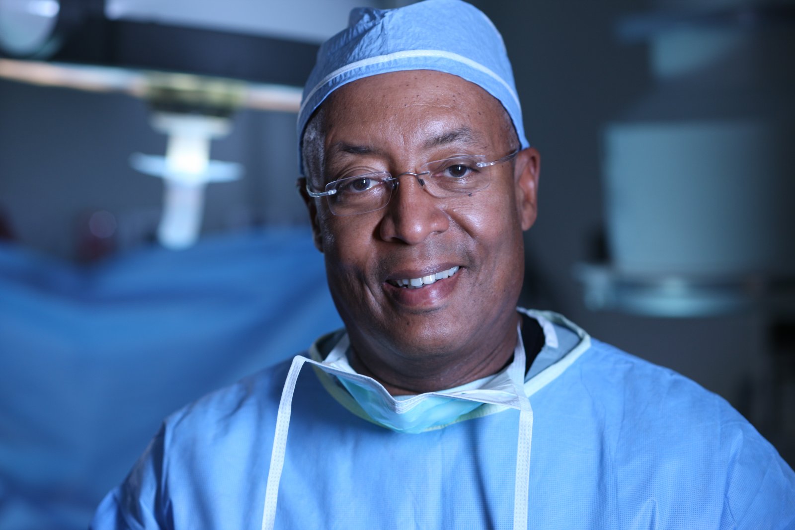 W. Bedford Waters MD poses in blue scrubs in an operating room